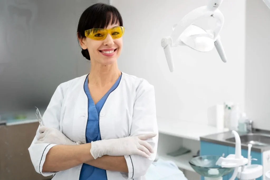 a woman who did a dental assistant course is smiling in a clinic